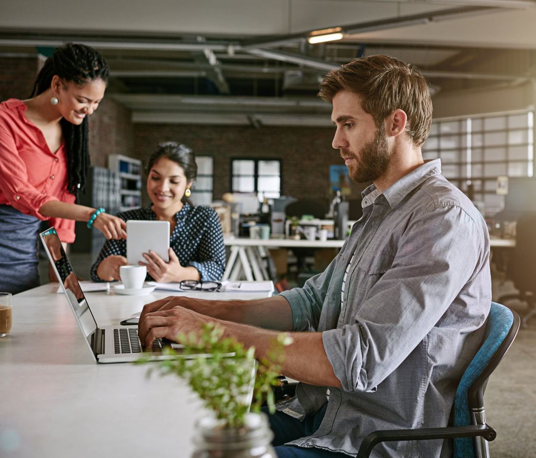 Team members reviewing work together in an open office