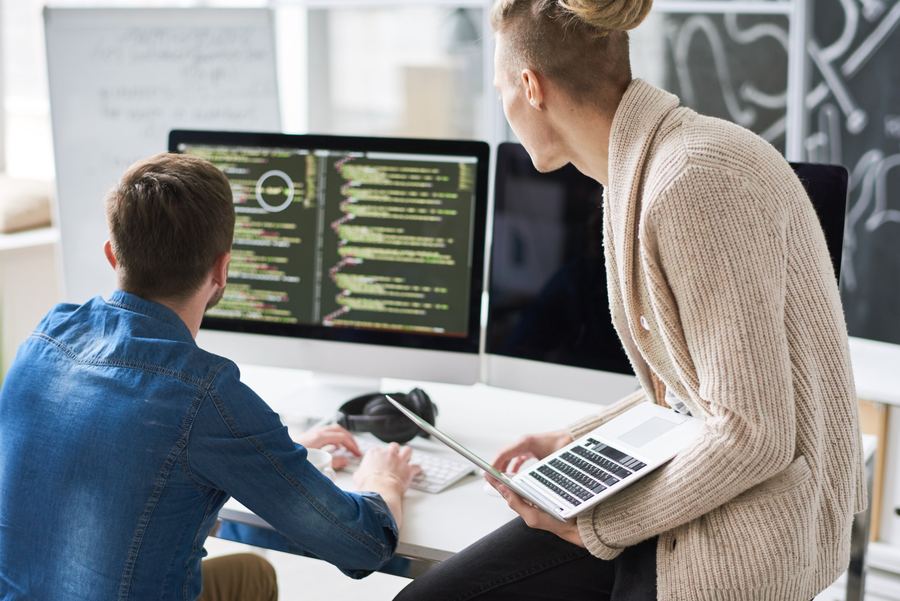 Two people building and reviewing a system on screen